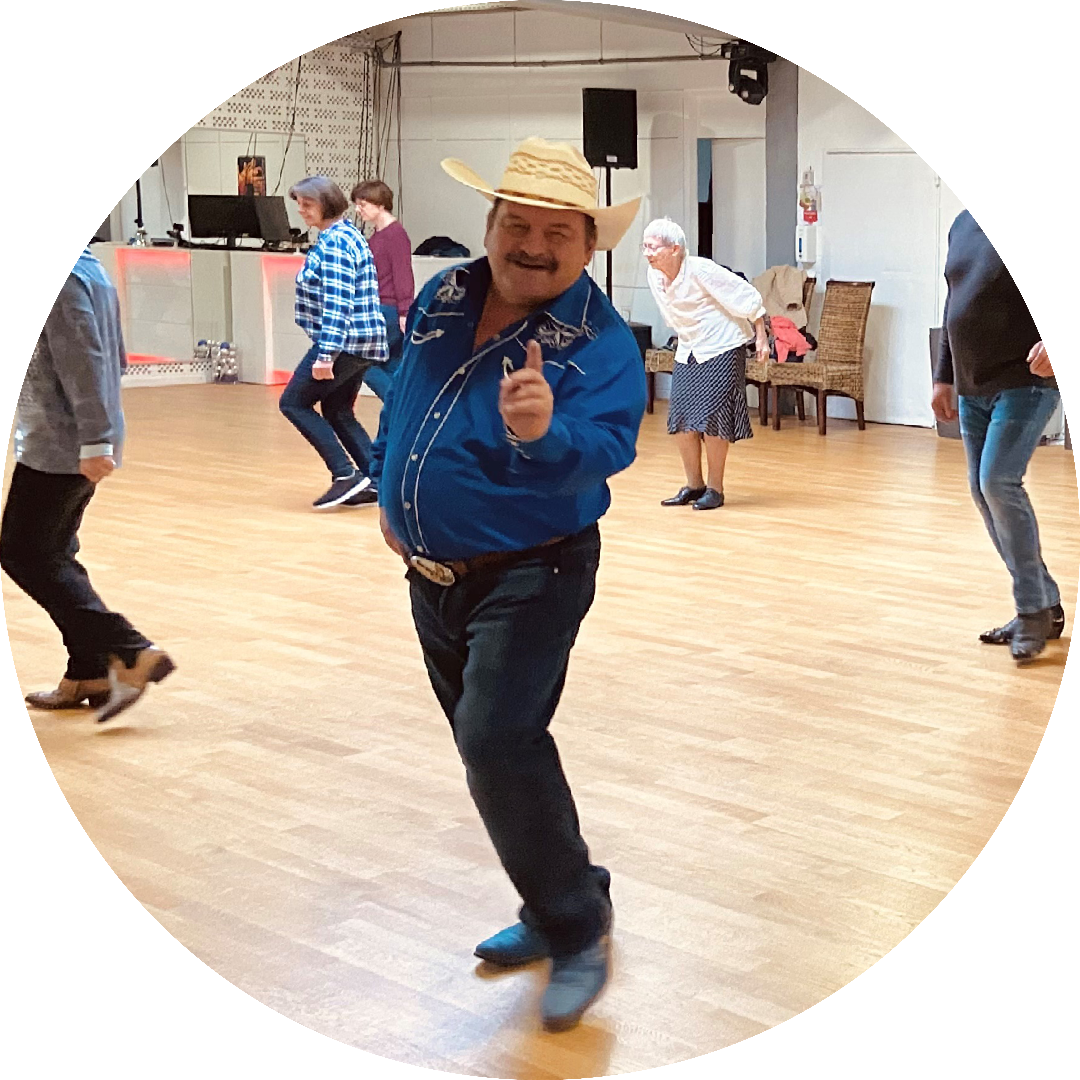 Countrylehrer mit Tänzern im Hintergrund