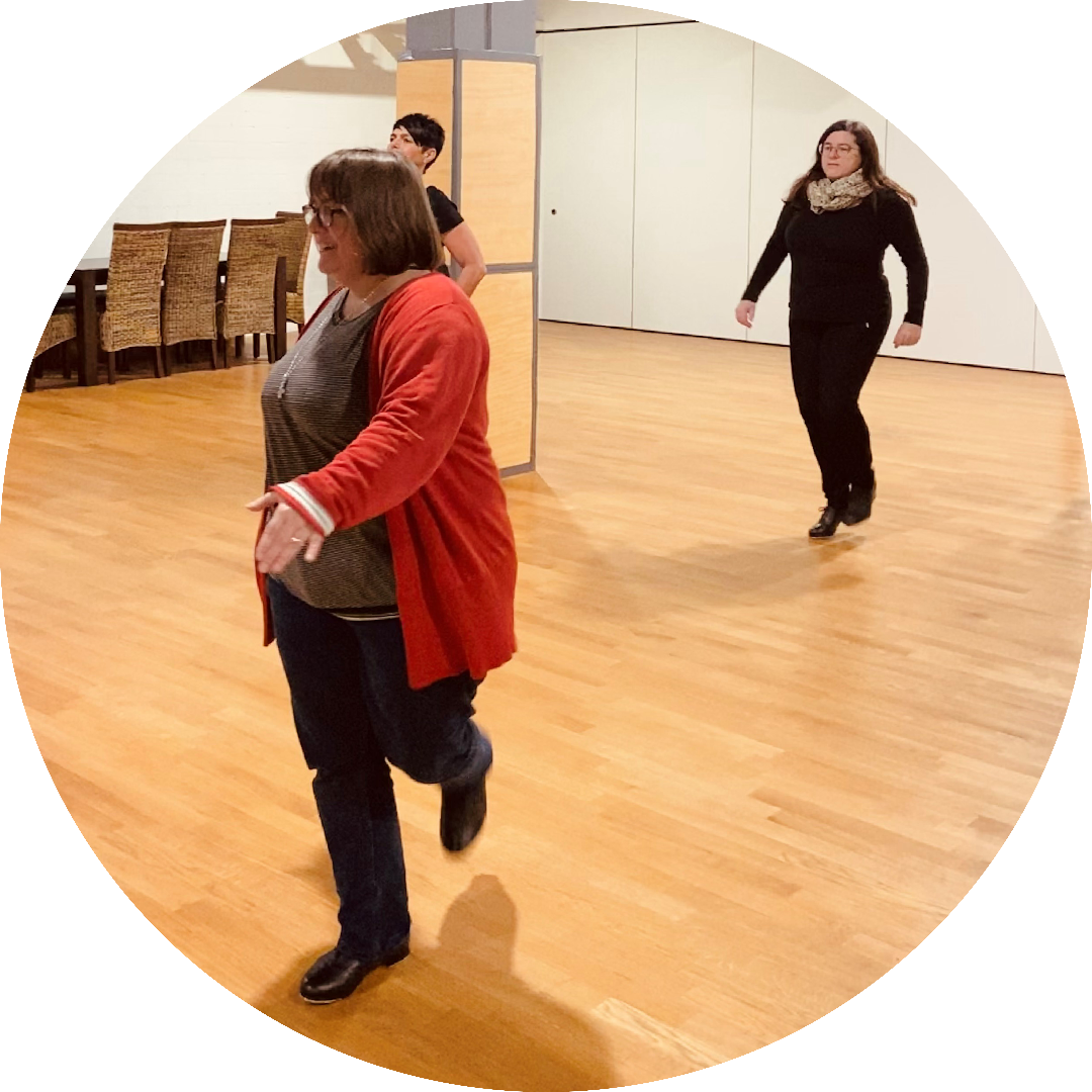 Stepplehrerin mit Teilnehmern im Hintergrund